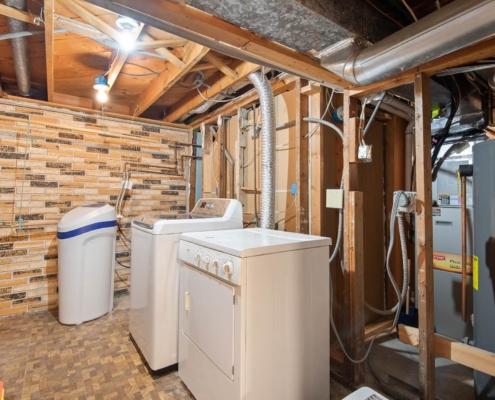 White washer and dryer in unfinished basement laundry room